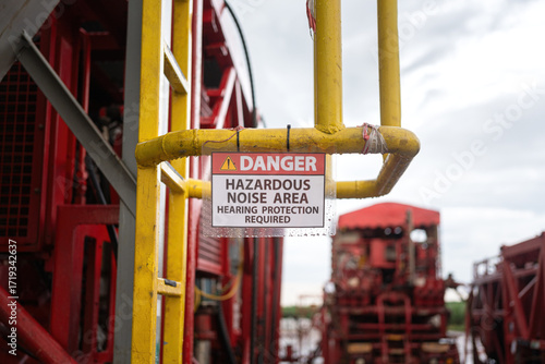 High noise working area warning, required to wear hearing protection. The safety sign at industrial refinery process plant. 