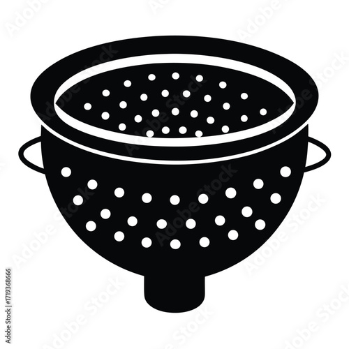 An isolated black colander showcases circular drainage holes in a simple kitchen preparation scene