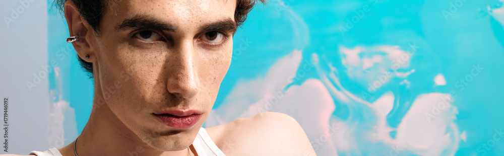 Obraz premium Stylish man in elegant attire poses with confidence against a vibrant backdrop