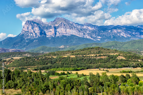 paisaje de altas montañas un valle con bosques verdes en verano y un cielo cargado de nubes, pirineo aragonés, Huesca, Spain