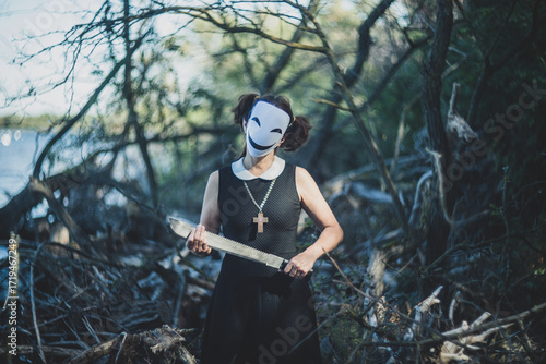 Masked schoolgirl in forest sitting quietly on autumn tree.