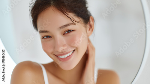 頬に手を当てて笑う美しい歯の女性【美容歯科】