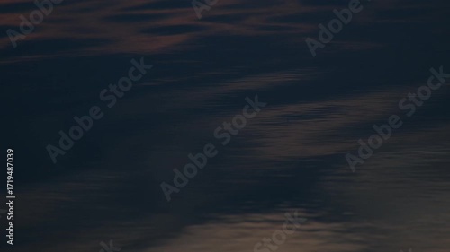 Dark water ripples with abstract light reflections. Liquid wavy surface motion. Dynamic ocean or lake texture footage.
