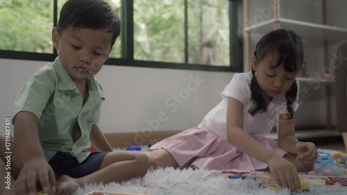 Girls and boys are playing with toys in the room, and the children are playing with colorful toys on the carpet on the floor.