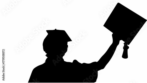 Silhouette of a graduate holding a diploma and wearing a graduation cap with a tassel in celebration