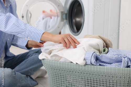 Quadro em tela Woman with laundry near washing machine indoors, closeup