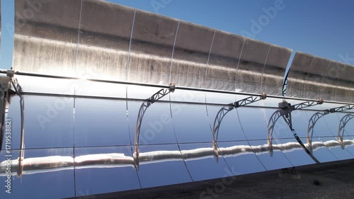 Solar thermal power plant with parabolic mirrors in a dry landscape. Renewable energy technology for clean electricity production and environmental sustainability.