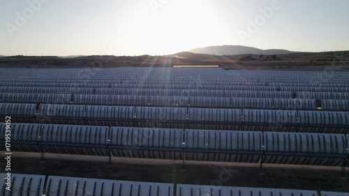 Solar thermal power plant with parabolic mirrors in a dry landscape. Renewable energy technology for clean electricity production and environmental sustainability.