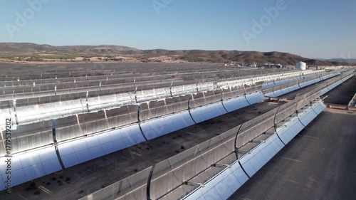 Solar thermal power plant with parabolic mirrors in a dry landscape. Renewable energy technology for clean electricity production and environmental sustainability.