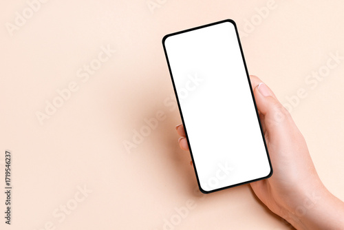 Hand Holding Smartphone with Blank Screen on Beige Background