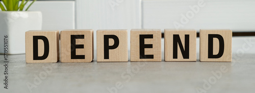 The word depend is written in wooden blocks on a gray surface
