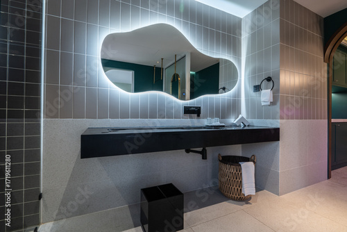 Modern bathroom interior with unique mirror and stylish decor.