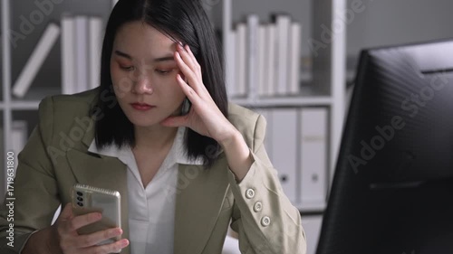 Young Asian Businesswoman looking stressed while talking on the phone
