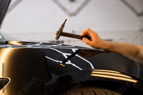 Man Repairing Vehicle Body Using PDR Tools