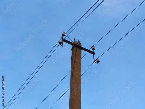Wallpaper Mural Old electricity pole with wires silhouetted against clear blue sky, symbolizing fading infrastructure and the passage of time in energy history.
 Torontodigital.ca