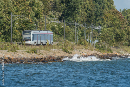 Aarhus, Denmark 13 09 2025 An Aarhus light rail (Aarhus Letbane) electric train travels alongside a cycle lane as it approaches the University Hospital