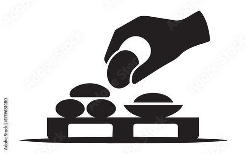 Hand placing an biscuits into a bowl on a pallet on white background