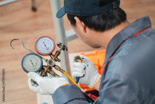 Technician Using Manifold Gauges for Cooling and Heating System Maintenance in a Modern Workshop Environment