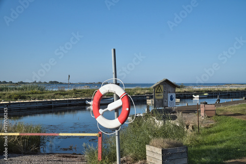 Lifebuoy at the small harbor with a view of the water and coastal landscape