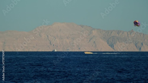 Speedboat with parachute parasailing on the Red Sea near Tiran Island.