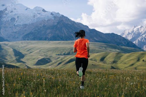 Female runner running on the high altitude grassland mountain top
