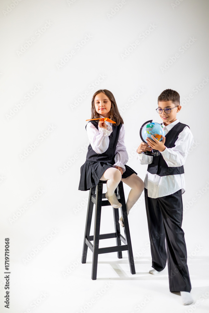 Obraz premium Two children, a girl and a boy, dressed in formal attire, exploring their creativity and curiosity about the world.