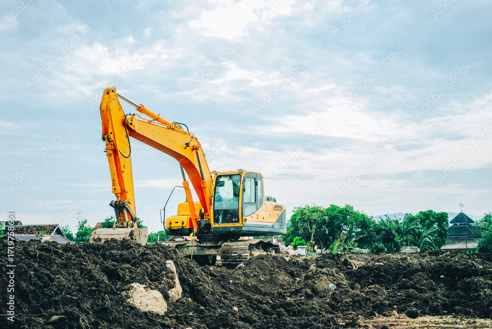 Obraz premium Excavator on limestone mountain. Backhoe digging sand, soil on limestone mountain, Heavy construction equipment is digging at construction site. Excavator is working on soil, foundation. Road construc