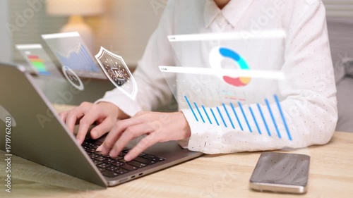 A person works on a laptop with holographic AI security icons and digital financial analytics charts, symbolizing fintech, data safety, and investment technology.