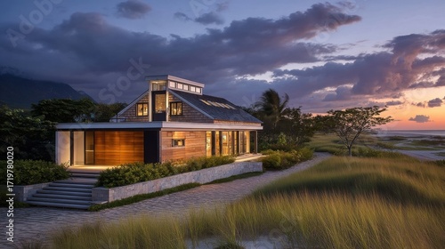 A contemporary beachfront home stands near calm waters at dusk, featuring modern architecture, large windows,