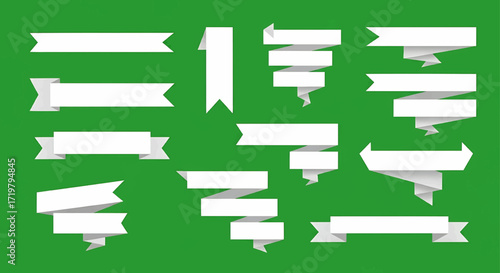 A collection of white ribbon banners with different shapes and folds, set against a plain green background.