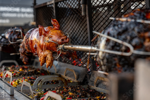 Obraz na plátně Vue d’un cochon entier cuit à la broche lors d’une préparation traditionnelle, illustrant une cuisson lente en extérieur avec une présentation conviviale