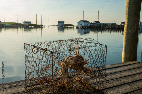 chesapeake bay style crab pot with fishing shanties in the background.