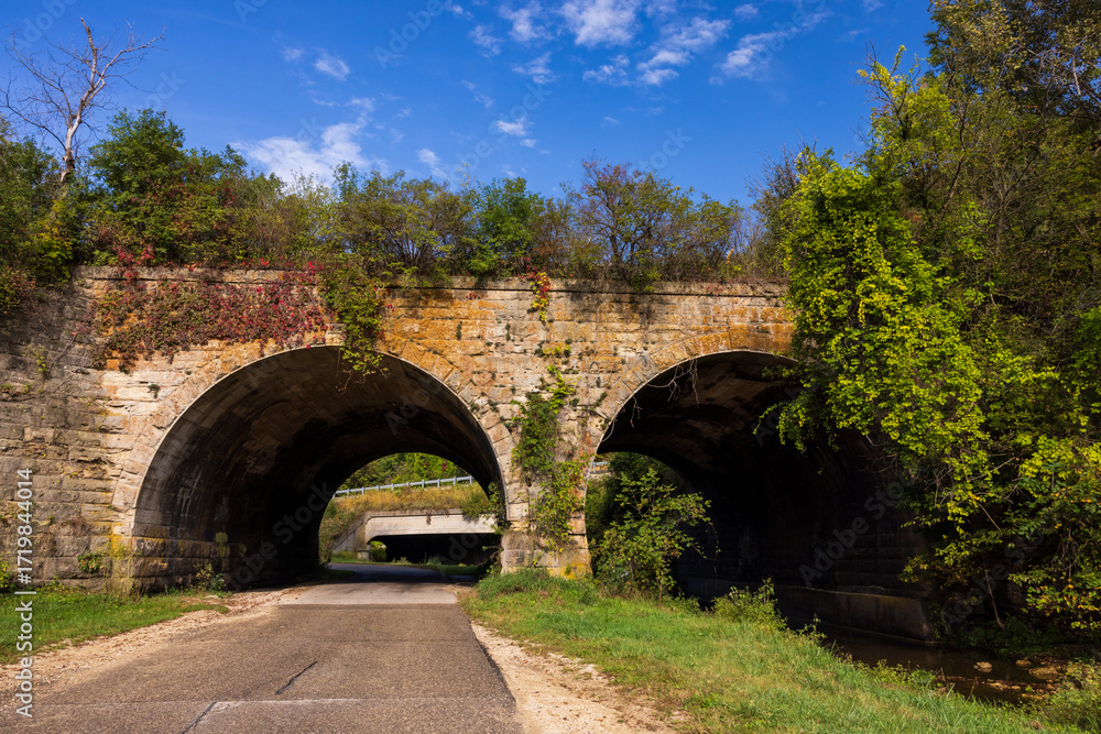 Fototapeta premium A Double Arch Stone Bridge With Road and Creek
