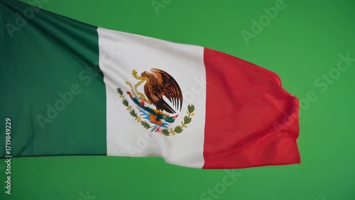 Ultra HD cinematic footage of the Mexican flag with green white and red vertical stripes and national emblem in the center waving slowly against a seamless bright green background with vivid fabric de