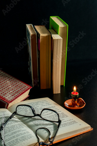 A stack of books with a candle on top of them
