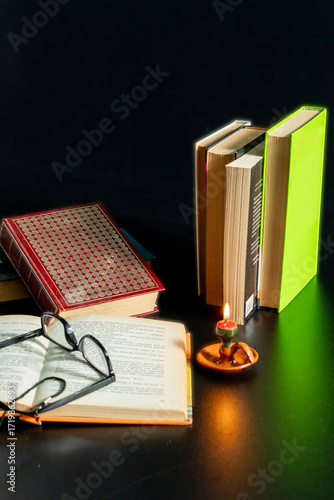 A stack of books with a candle on top of them