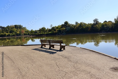 The empty wood bench at the lake in the park.