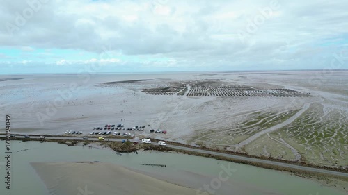 Aerial view of oyster farms at low tide near the Passage du Gois, Noirmoutier Island, France. Long rows of oyster beds and water channels create a unique landscape, showcasing traditional oyster

