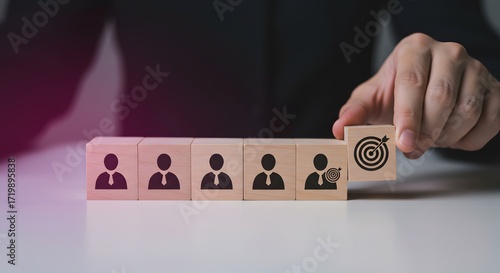 Teamwork and Goal Achievement Concept: Hand placing a target cube with an arrow hitting the bullseye next to employee icons