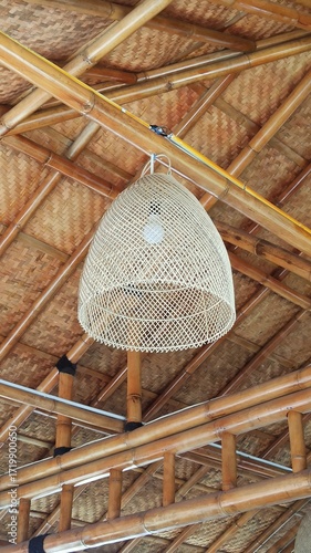 A decorative lamp crafted from woven rattan, casting warm light through natural patterns and showcasing elegant handmade craftsmanship.