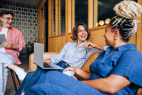 Foto Group of professionals laughing and discussing ideas in a cozy office setting