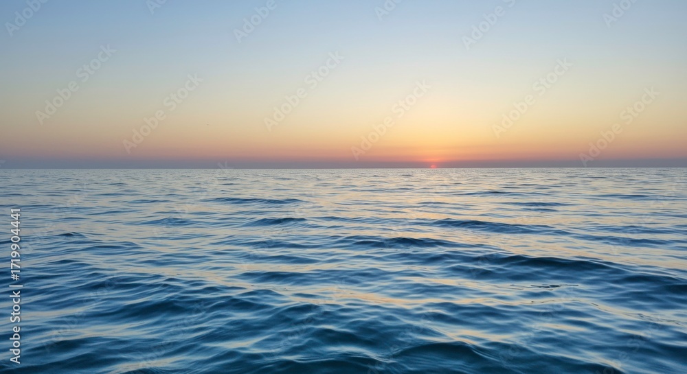 Obraz premium Peaceful seascape with gentle waves reflecting the golden light of the sunset horizon