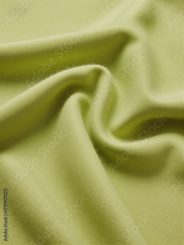 close up of lime olive green folded and twisted woolen fabric background