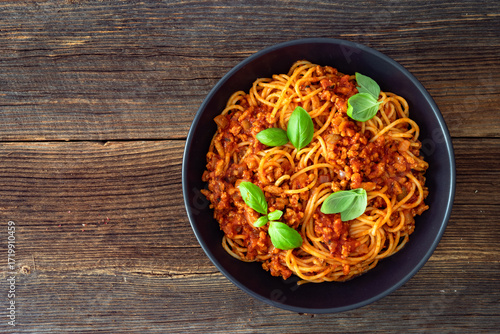 Spaghetti con ragù alla bolognese - pasta with minced meat and tomato sauce on wooden table