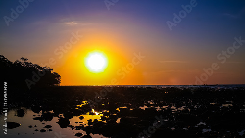 Canvas Print the sea water began to recede on the beach as the sun began to set