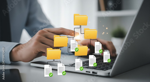 Businessman working on a laptop with file management concept and document organization in digital world. The files are shown as linked documents and folders