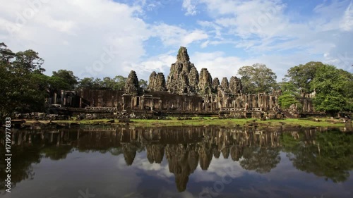 The ancient bayon temple reflecting in the water in angkor, cambodia