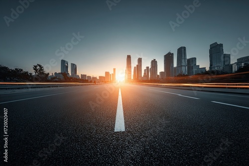 Urban City Skyline at Sunrise with Empty Road Leading Toward Tall Skyscrapers