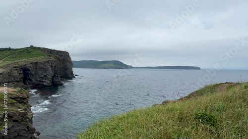 Rocky island of Vladivostok. Fog, seagulls circling over the sea