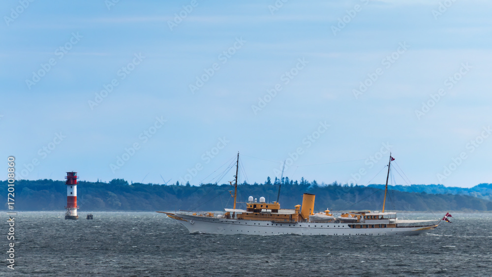 Fototapeta premium Aufnahme der königlichen Yacht von Dänemark bei einem Leuchtturm.